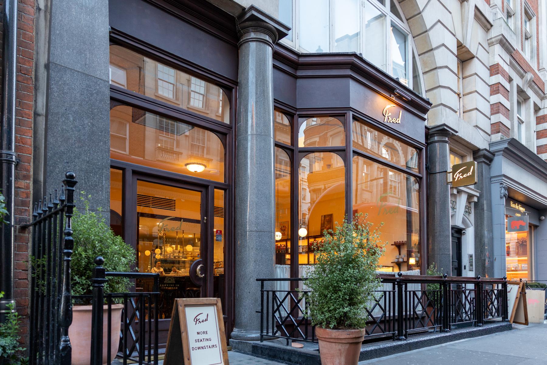 Fred shopfront with dark timber door and frame, arched glazing and gilded lettering