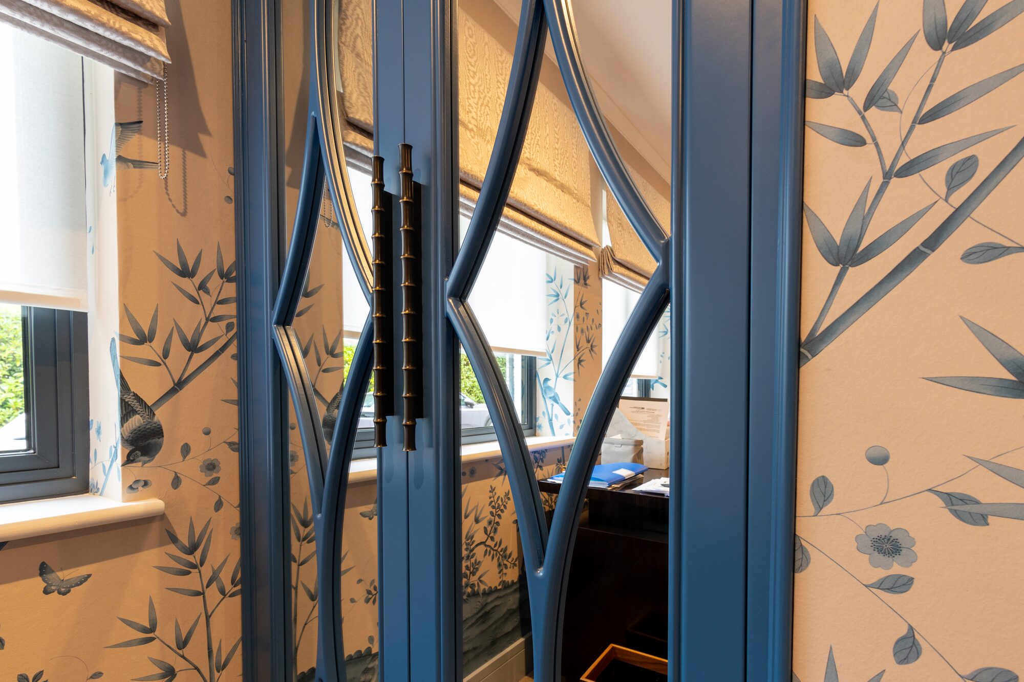 Mirrored cabinet doors with diamond glazing bars and bamboo-form brass handles